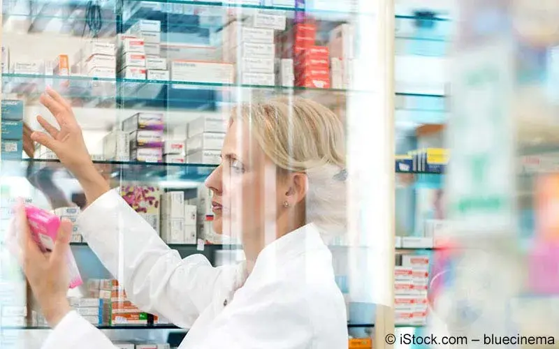 Apothekerin schaut auf ein Medikament