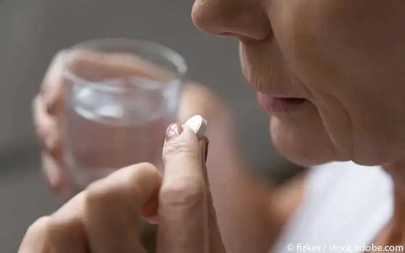 frau-nimmt-tablette-mit-wasser