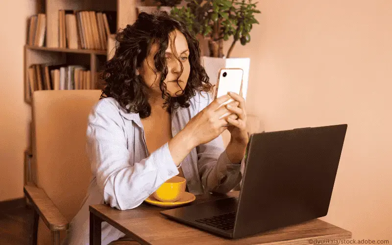 Frau_nutzt_Handy_und_Laptop_Arbeit