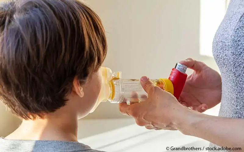 Kind inhaliert mit Vorschaltkammer