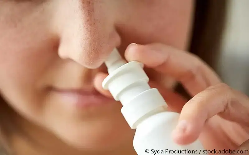 Patientin nutzt Nasenspray