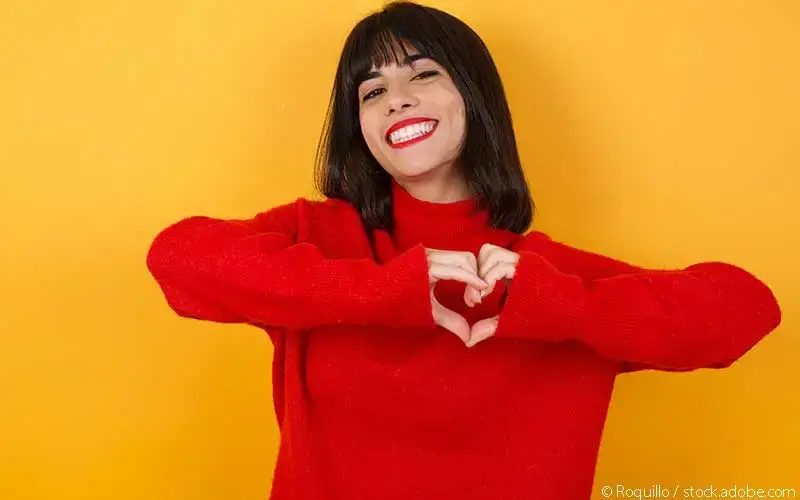 Frau roter Pullover gelb-oranger Hintergrund