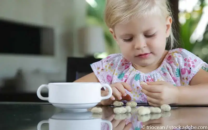 Kleines Mädchen isst Erdnüsse