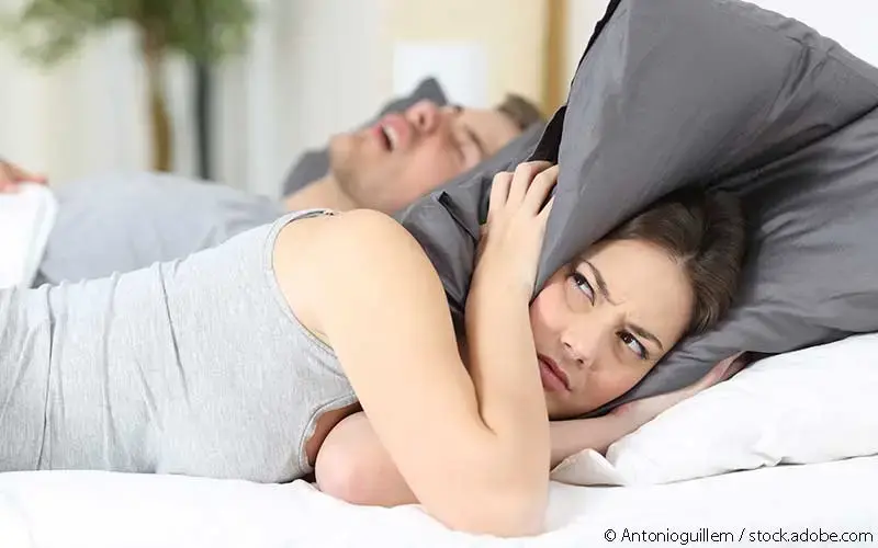 Mann schnarcht im Bett