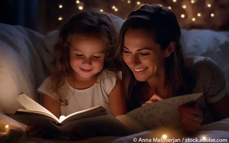 Mutter liest Kind im Bett vor